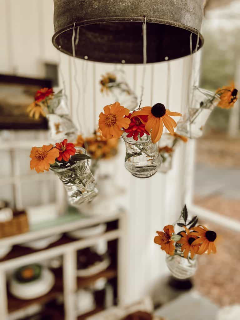 Industrial Light fixture gets a warm cozy feel with fresh cut flowers and herbs for a Late Summer Tablescape.