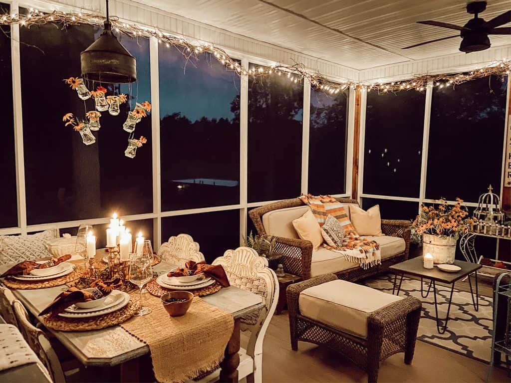 As evening approaches, the candlelight and twinkling garland looks cozy on this summer porch. 