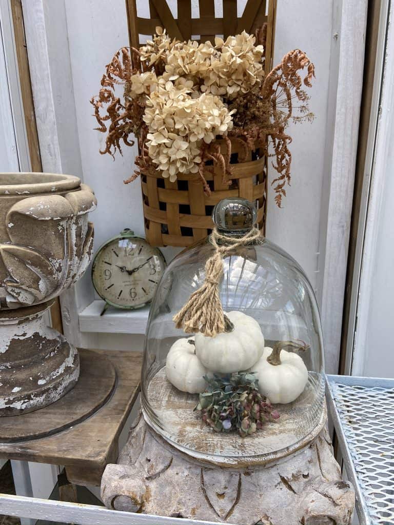 Add a DIY Jute Tassel to the top of a glass cloche for fall decorating.  Fill cloche with faux pumpkins and dried hydrangea stem. 