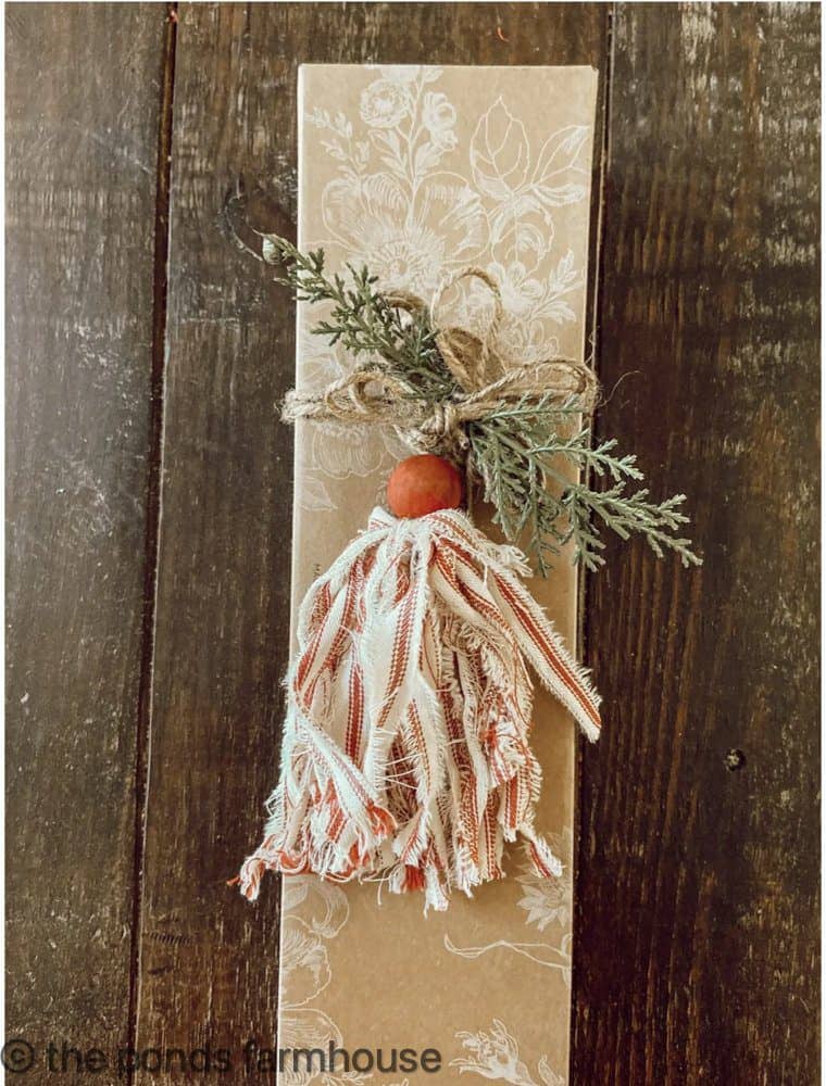 DIY Red and White Ticking Tassel used as a Christmas Gift Wrapping Package Topper.  