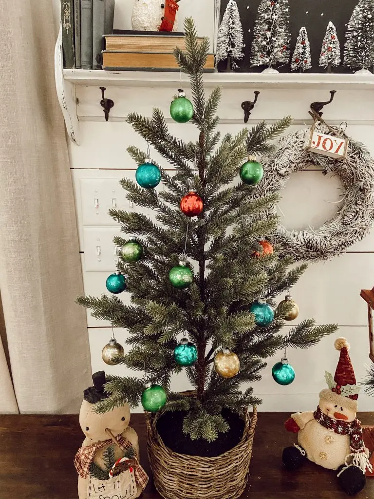 Here is the absolute easiest way to age new Christmas Ornaments to make them look like vintage shiny brites.  Make your new ornaments have a rustic, faded appearance using this no mess method.  Only takes minutes to create a whole tree full of antique looking ornaments.  