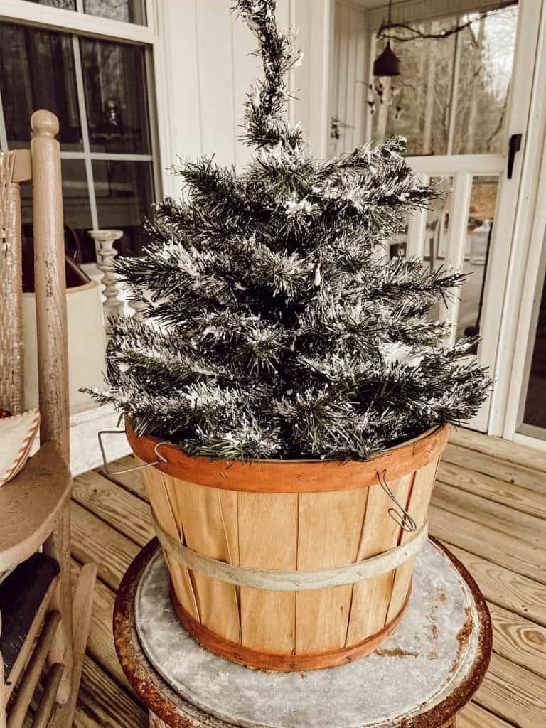 Old Fruit Basket Holds Flocked Mini Christmas Tree on Front Porch