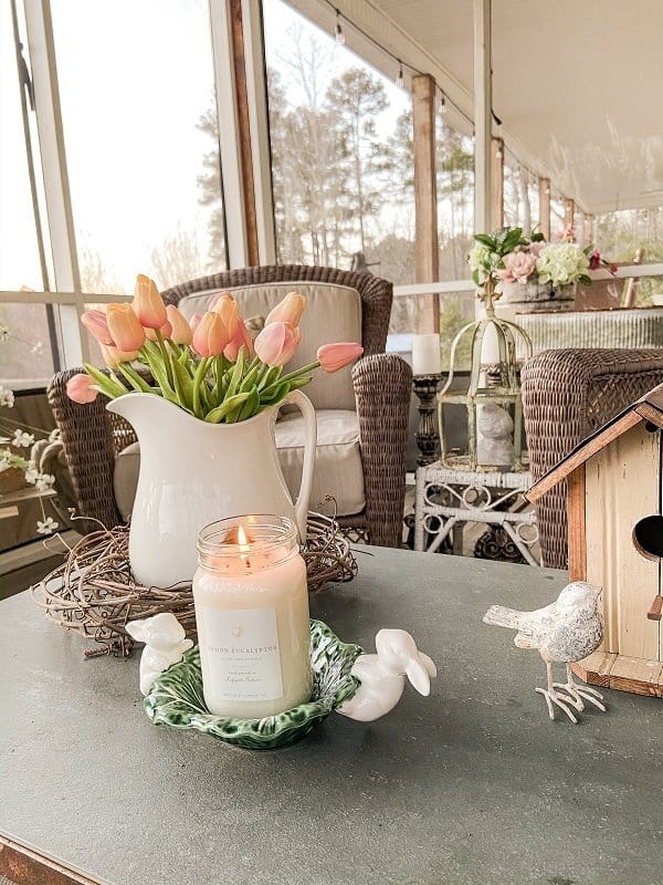 Slate coffee table with ironstone pitcher Easter bunnies bird house and candles.