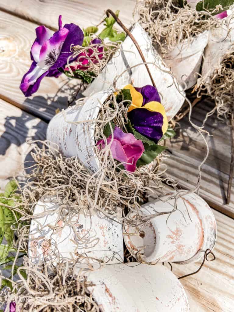 Pansies in faux aged terra cotta pots added to Spring Outdoor Wreath - outdoor wreath ideas.