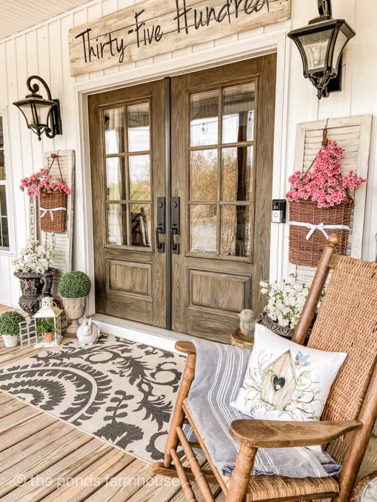 Spring Porch with outdoor rug ideas at front door with baskets of pink flowers at french doors