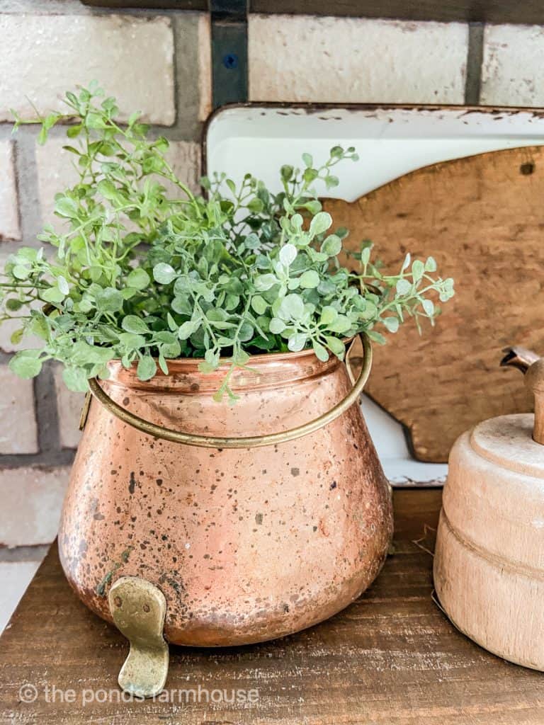 Thrift Store copper pot filled with faux greenery  on open shelf in farmhouse kitchen