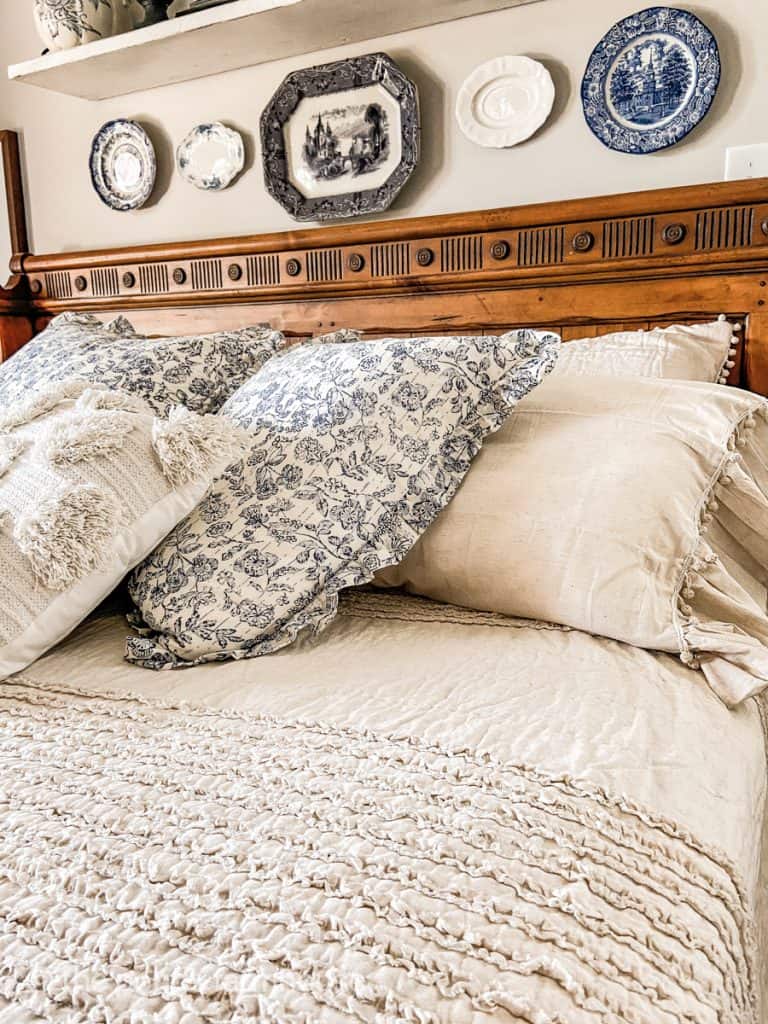 Easy farmhouse style bedroom ideas for Spring with ruffled bedding and blue and white florals.