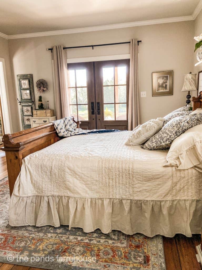 Ruffled Farmhouse Style bedding in primary bedroom with french doors leading to the porch.