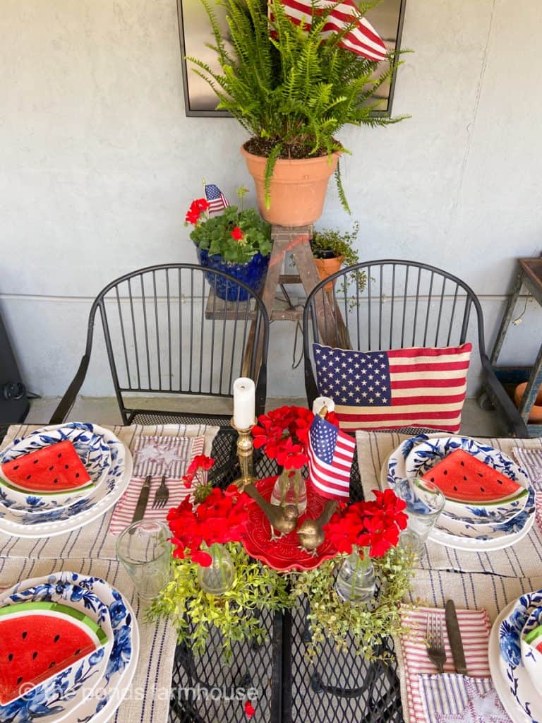 Red White and Blue Table setting for the Fourth of July with centerpiece and blue and white plates. 
