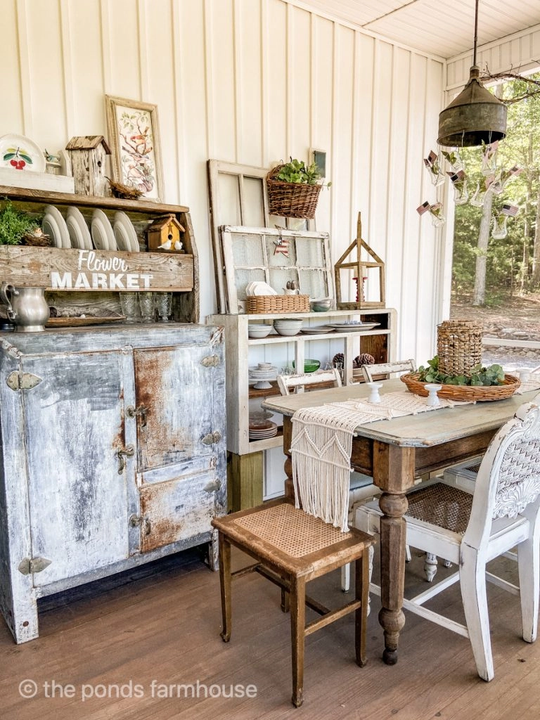 Screened porch dining area with vintage farmhouse style decor.  