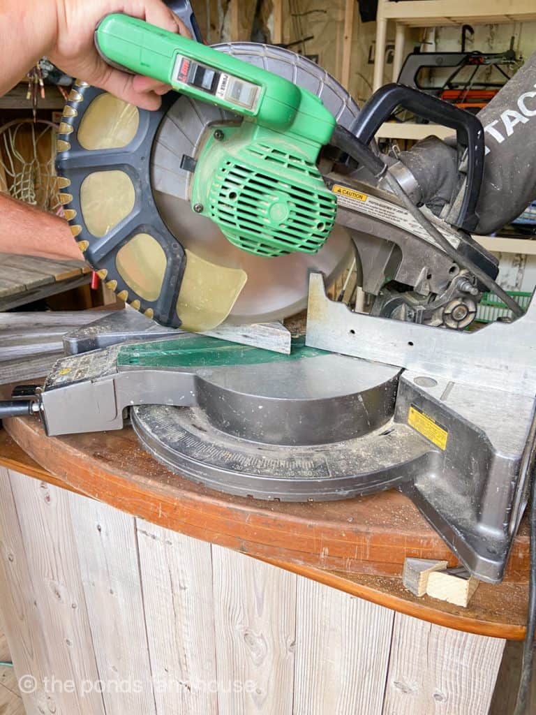 Use miter saw to cut angles on the reclaimed wood for a obelisk.