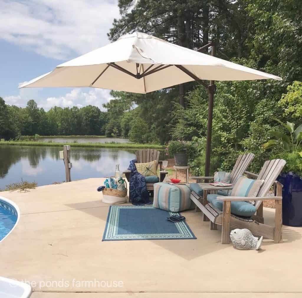Outdoor Rug for pool area with blue rug and blue seat cushions under umbrella. 