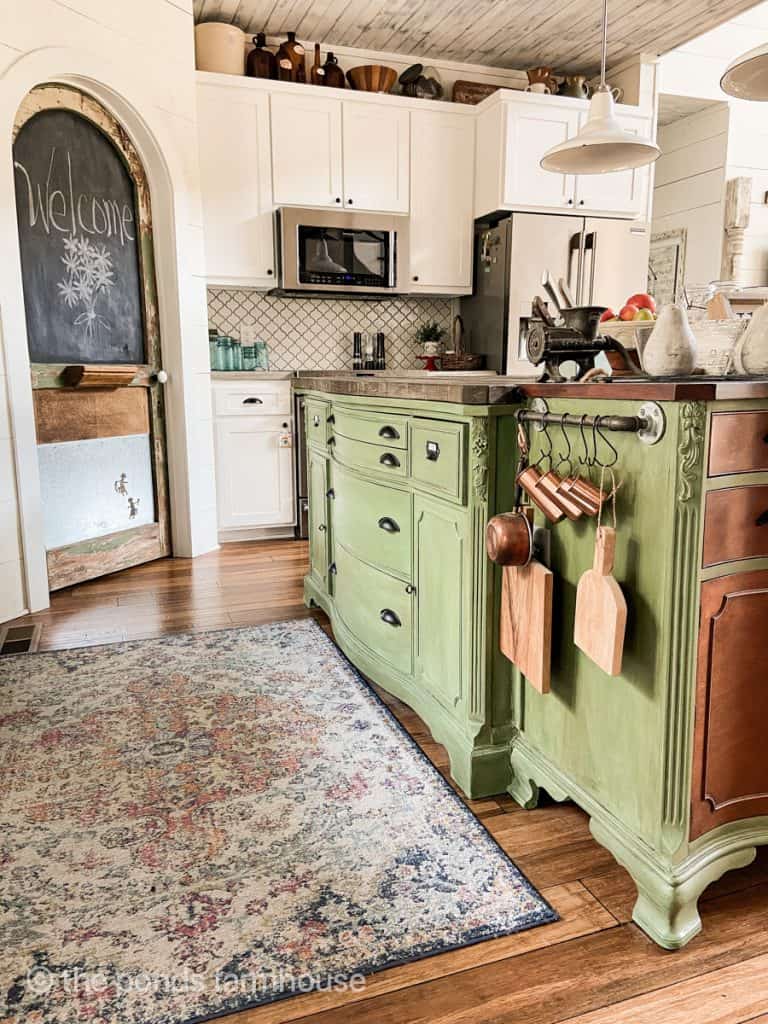 Updated DIY Farmhouse Kitchen Island painted green.  Island top is a faux barn wood finish for a rustic style.