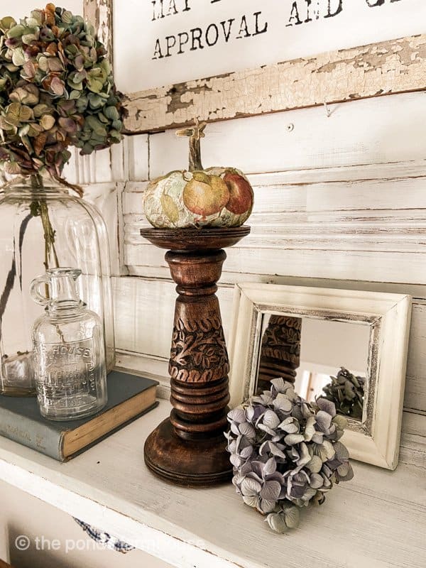 Decoupage Pumpkin on wood candle stick and dried hydrangeas with vintage mirror on old mantle upcycle