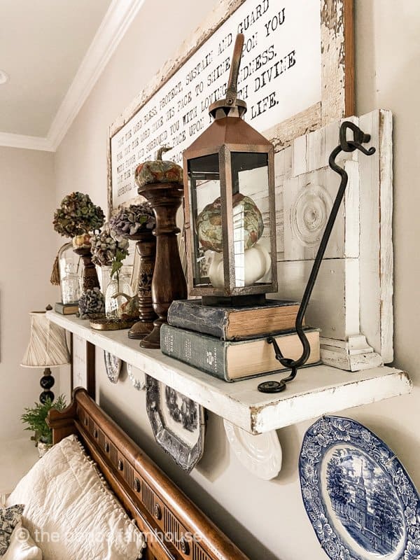How to Repurposed a Fireplace Mantel into a up-cycled wall shelf. Filled with fall decorations and blue plates. 