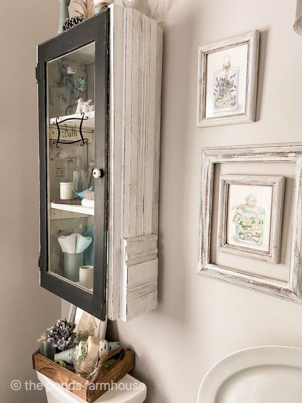 Repurposed Fireplace Mantel legs used to make bathroom wall cabinet with up-cycled materials. 