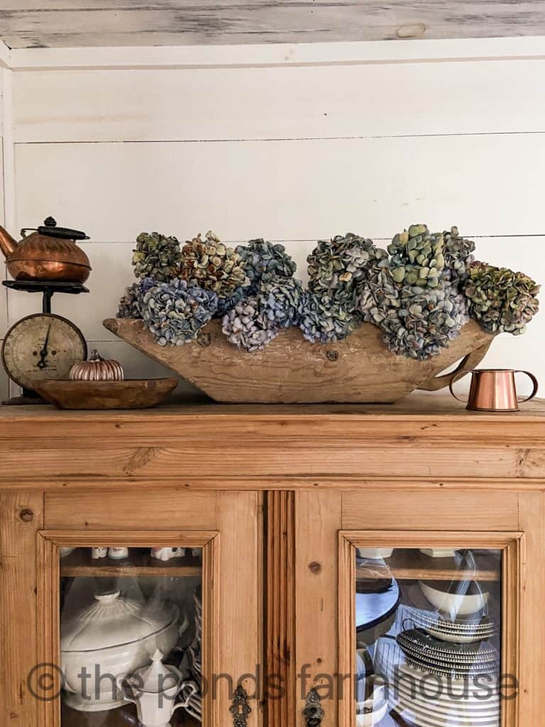 A dough bowl full of dried hydrangeas for autumn decor 