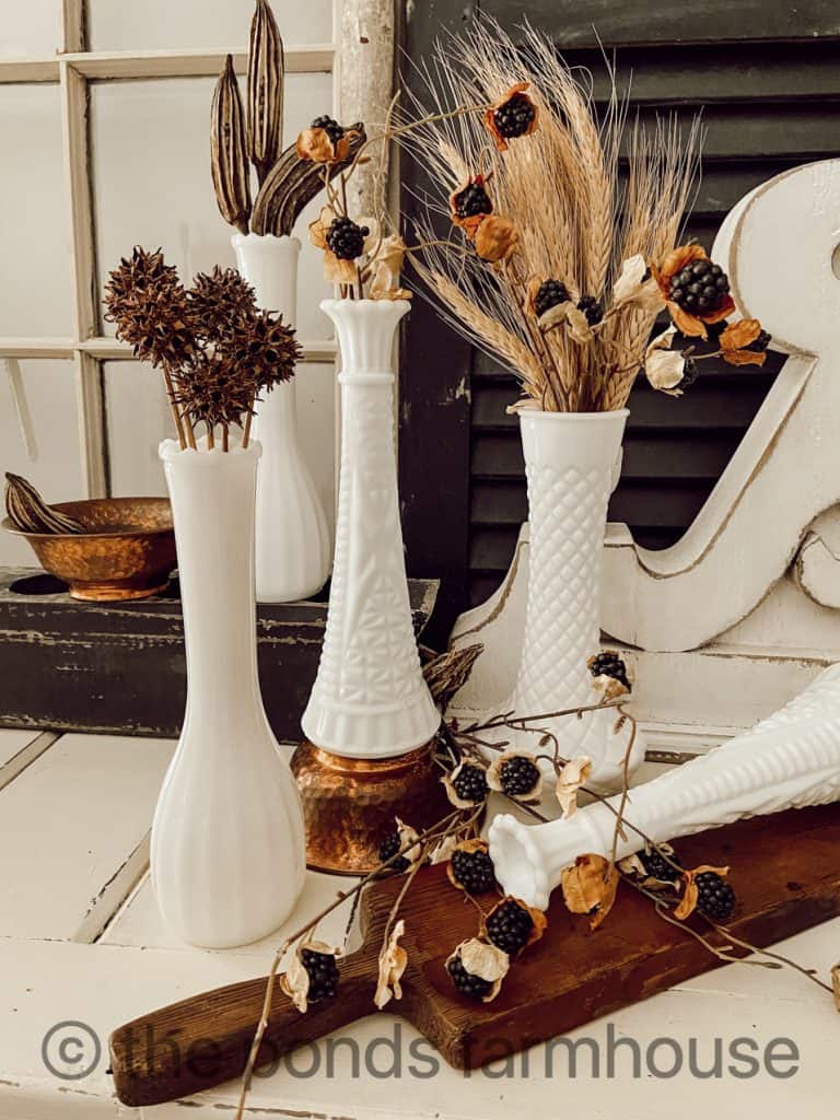 Milk glass vases with foraged craft fall displays.