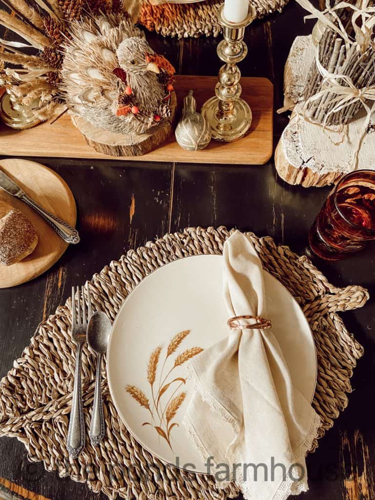 Thanksgiving table with wheat plates and copper napkin rings.