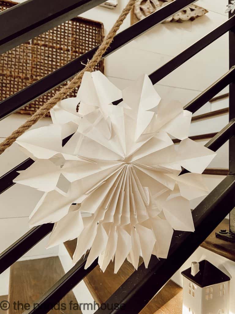 Creative Paper Bag Snowflakes made from White Paper Bags in a variety of shapes for the banister railing.