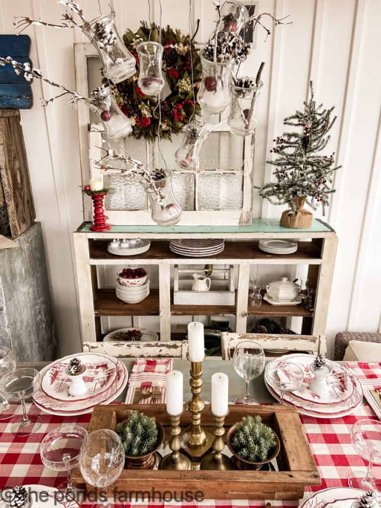 Vintage shelving with Christmas tablescape. Vintage Christmas plates. Brass candle holders.