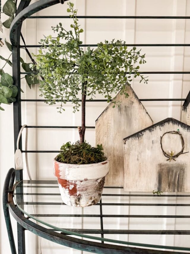 Easy DIY Topiaries sitting on a bakers rack. Wooden village .