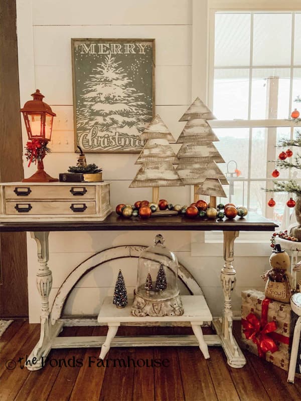 Entry Table decorated for Christmas with wooden trees and vintage garland