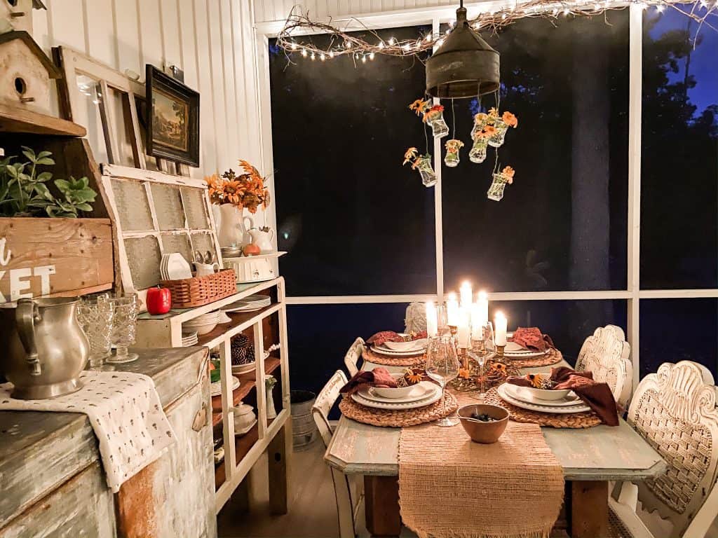 As evening approaches, the candlelight and twinkling garland looks cozy on this summer porch.  