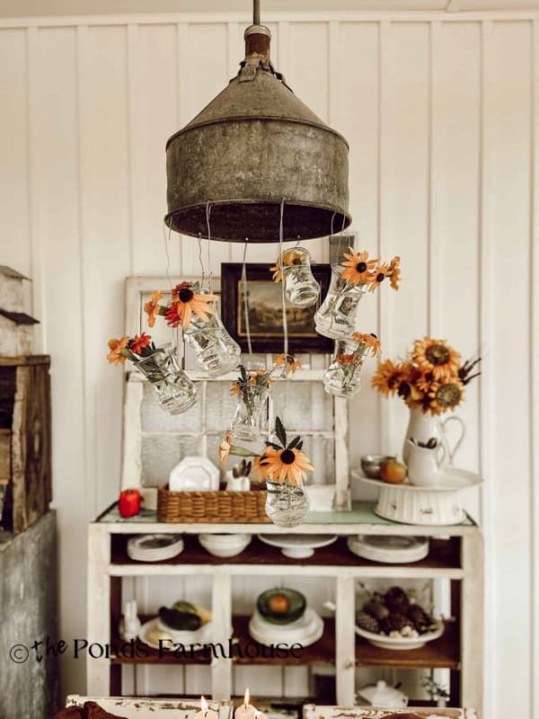 black eyed susans in light fixture vase over fall tablescape