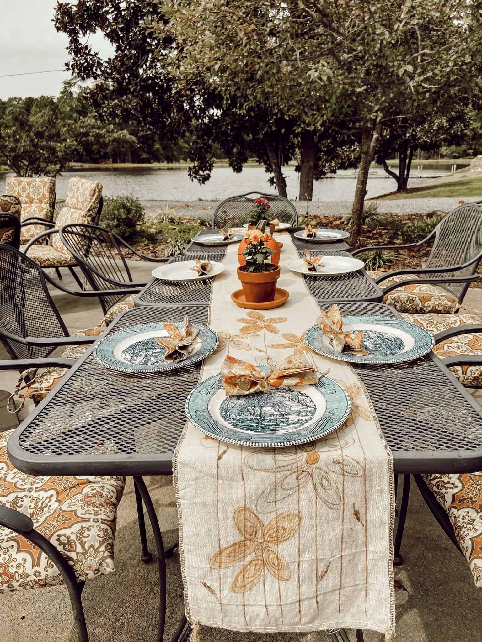 Hand painted fall table runner made from drop cloth fabric on outdoor kitchen table setting.  