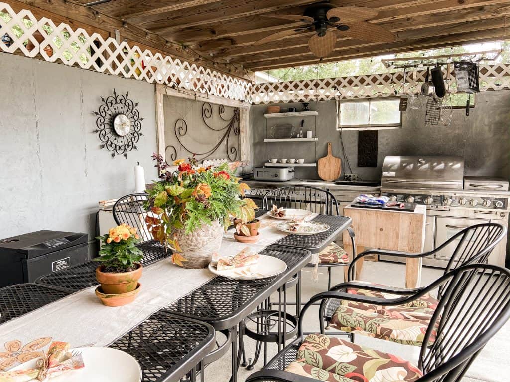 Fall Decorating Outdoors in Outdoor Kitchen with metal bistro tables and DIY earthenware centerpiece with fresh flowers