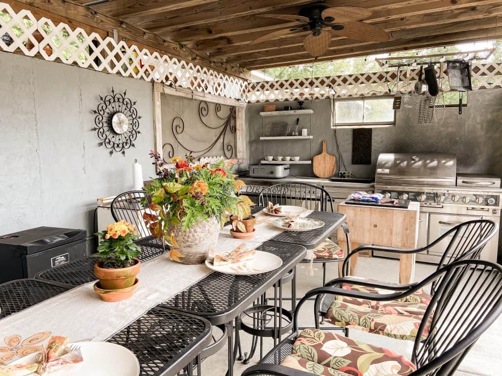 Outdoor Kitchen using a DIY Earthenware vessel with fresh cut flowers and autumn leaves for table centerpiece