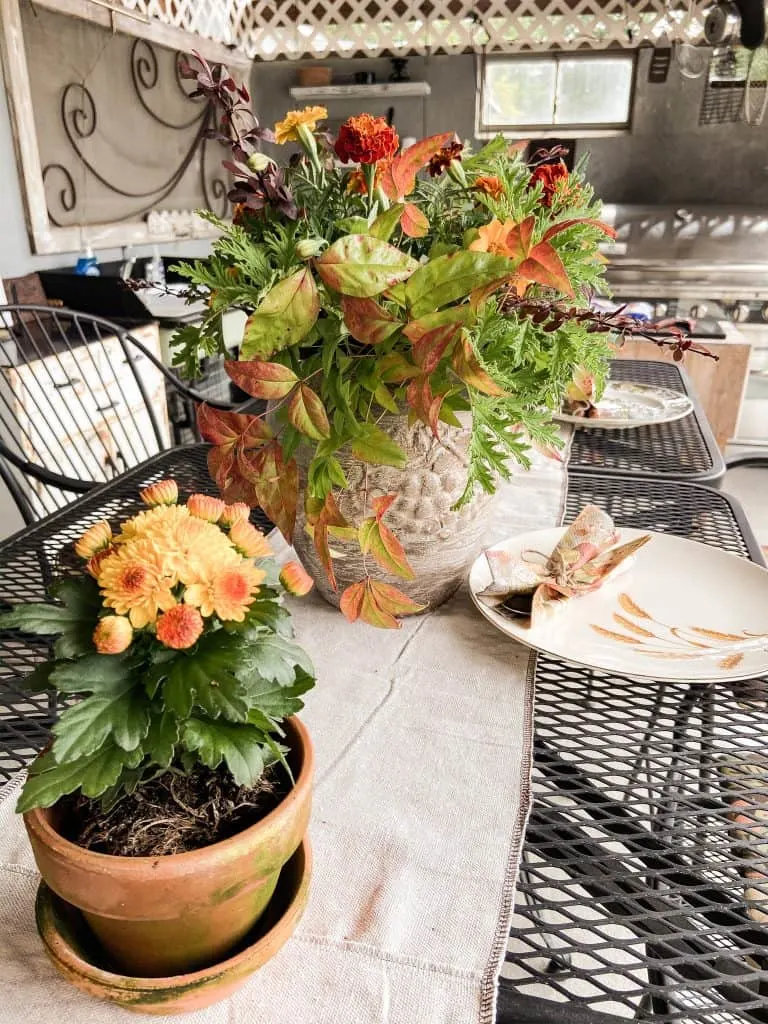 Ideas for Fall Decorating outdoors with fresh flowers in outdoor kitchen, vintage tableware.  Outdoor tablescape