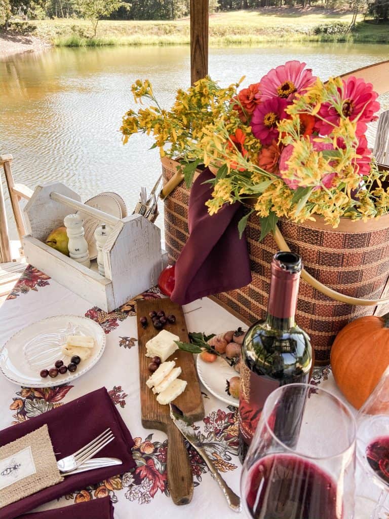 Picnic for two on outdoor table on pier at the ponds farmhouse.