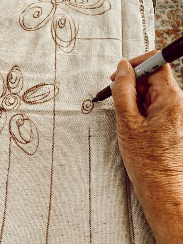 Use sharpie pen to draw flowers and stems on drop cloth for painting