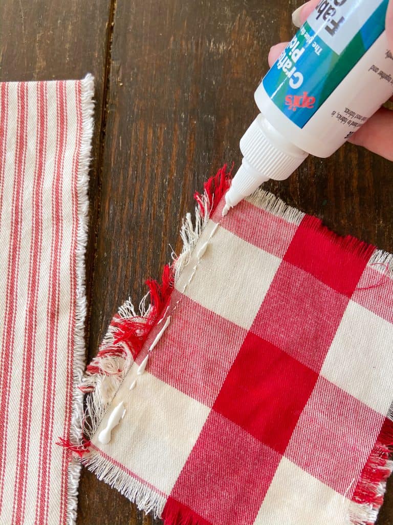 Use fabric glue to attach pocket for no-sew Christmas DIY Cutlery Pocket Napkins.