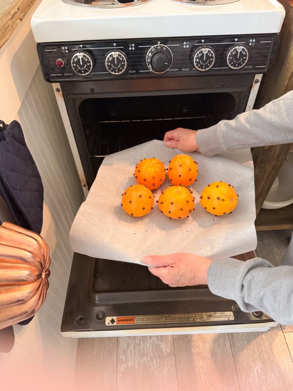 Place whole oranges on parchment paper and bake in oven to dry.
