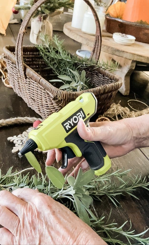 Use Hot glue to attach dried fruit to the fresh herbs, rosemary and sage herbs with dried orange slices.  