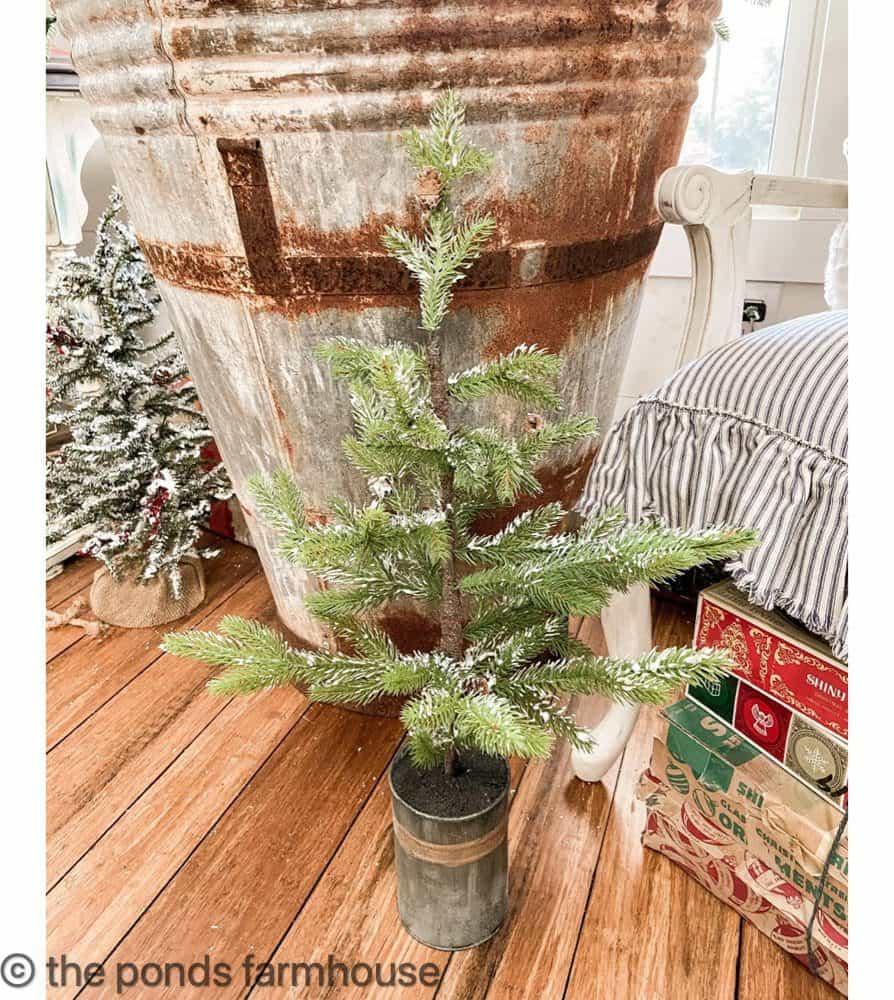 Small Fake Snow Christmas tree with vintage shiny brite ornament boxes.