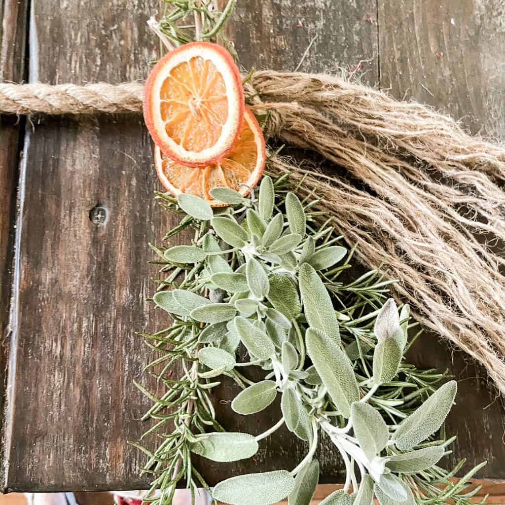 jute twine, dried orange slices and fresh rosemary and fresh sage on a jute garland