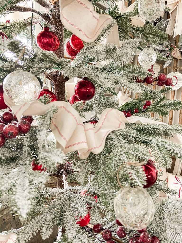 frosted tree with red and white ornaments and ribbon. 