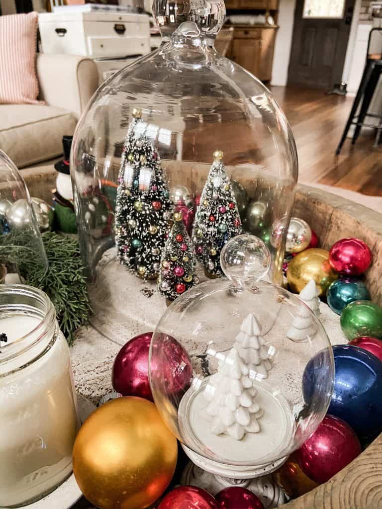 Large European Wood Bowl holds vintage ornaments, mini Christmas bottle brush tress under Glass Cloches 