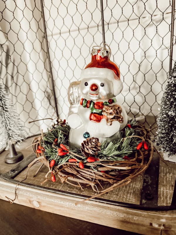 Use DIY Holiday Candle Ring to hold a vintage snowman ornament.