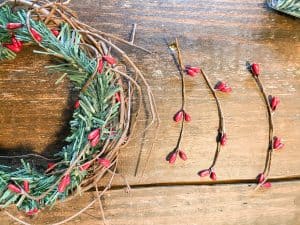 Use small pieces of the berry garland to attach to the grapevine wreath