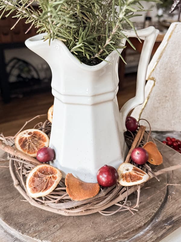 Rustic Farmhouse grapevine candle ring around an ironstone pitcher with dried oranges, cinnamon sticks and berries.  