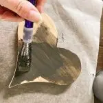 Paint wooden hearts with watery black paint to stain the wood.