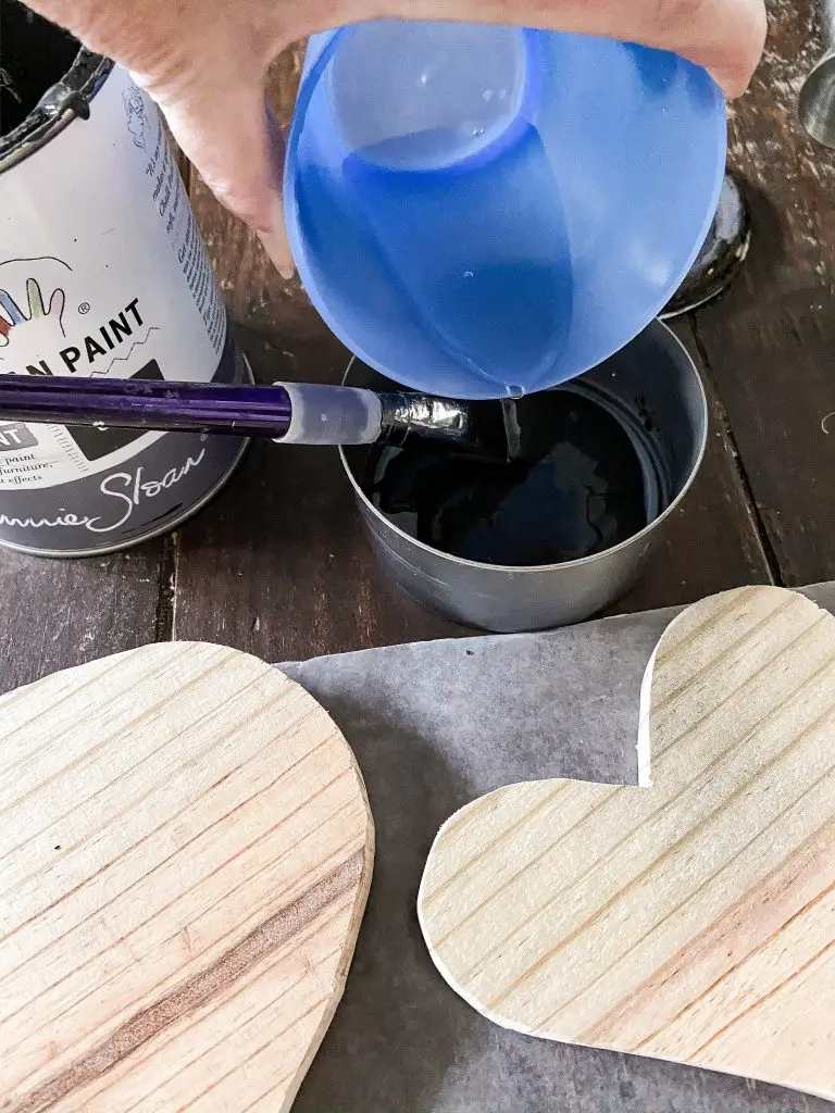 Stain wooden hearts for Valentines Day Craft Ideas with black paint and water.