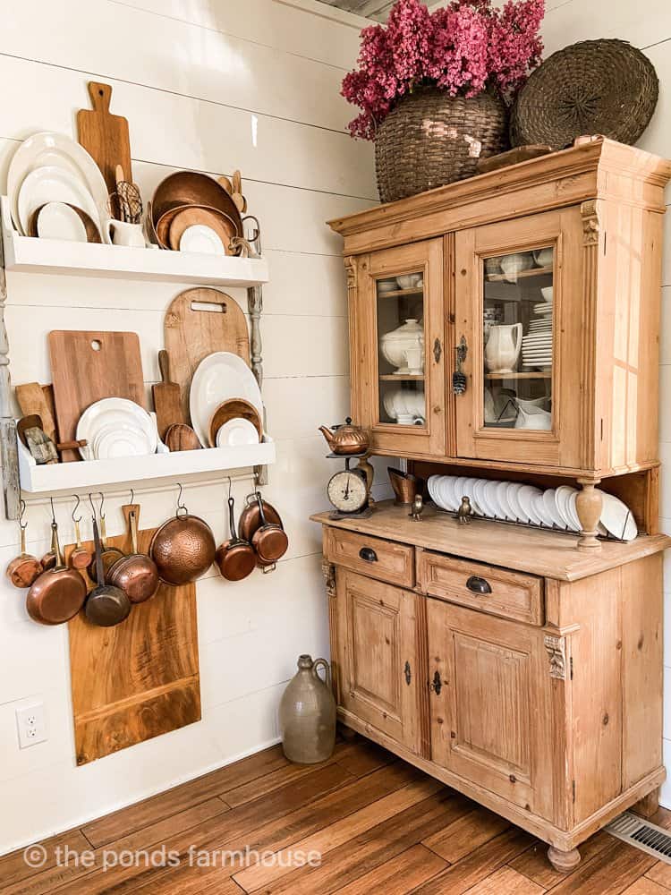 Antique Hutch with ironstone and large vintage basket filled with fresh flowers.  DIY Plate Rack on wall.  