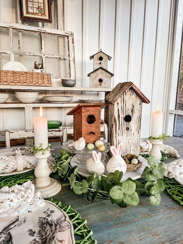 Easter screened in porch table setting. Vintage birdhouses, Easter bunnies and bunny plates.