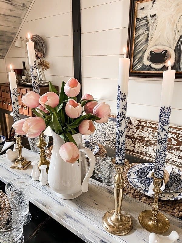 Blue and white candlesticks with pink tulips for a farmhouse style Spring dinner table.  